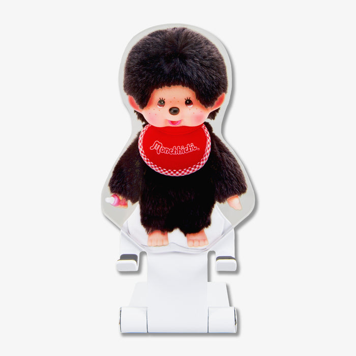 Front view of Monchhichi Boy character phone stand showing plush figure with red Monchhichi bib on a white adjustable stand