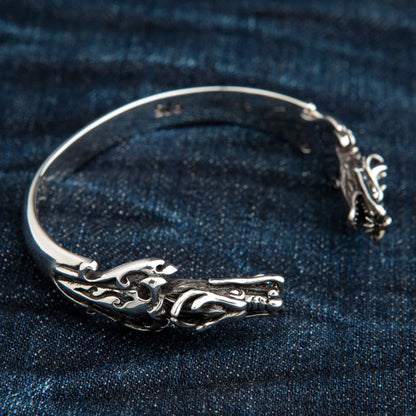 An angled view of the sterling silver dragon cuff, showing the detailed dragon head and polished band.