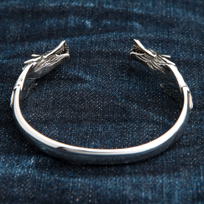 A top-down view of the dragon cuff bracelet, showing both intricately carved dragon heads.