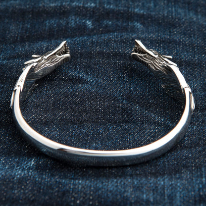 A top-down view of the dragon cuff bracelet, showing both intricately carved dragon heads.