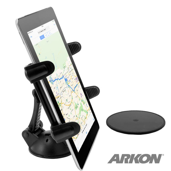 An iPad is held upright in the Sticky Suction Windshield or Dash Slim-Grip® Tablet Mount with adjustable grips; a round adhesive disc lies beside it. The ARKON logo appears at bottom right—ideal for ELD systems and navigation.