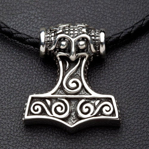 Front view of the solid sterling silver Thor's Hammer pendant featuring swirling Norse engravings on a black braided cord.