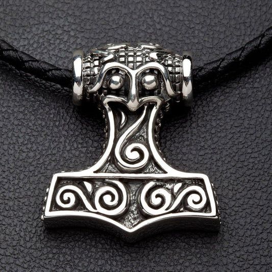 Front view of the solid sterling silver Thor's Hammer pendant featuring swirling Norse engravings on a black braided cord.