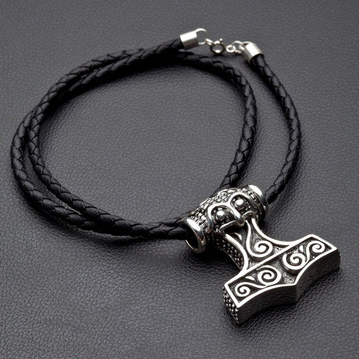 Complete silver Mjolnir necklace displayed flat, featuring the heavy pendant and its coiled black braided leather cord.