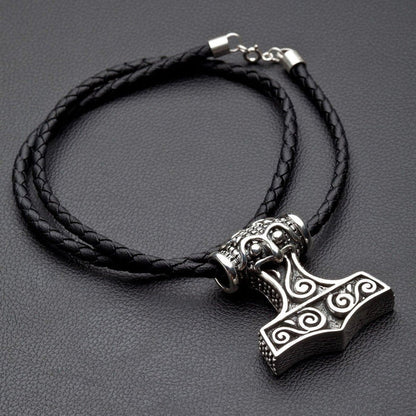Complete silver Mjolnir necklace displayed flat, featuring the heavy pendant and its coiled black braided leather cord.