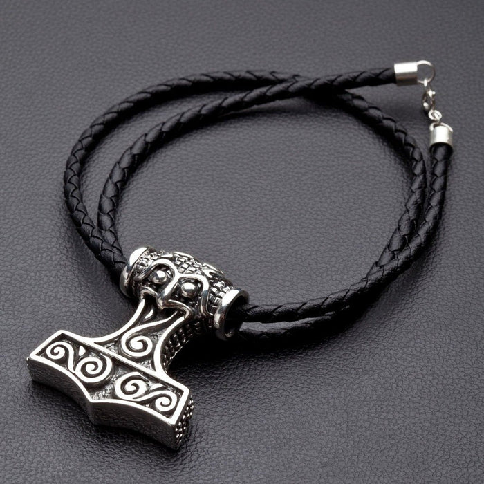 Solid .925 silver Mjolnir pendant attached to a looped black braided cord, resting on a dark textured surface.