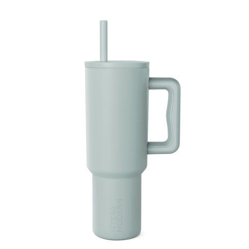 Sage green signature tumbler with handle and reusable straw, displayed on white background. Modern drinkware design with soft muted color and cylindrical shape.