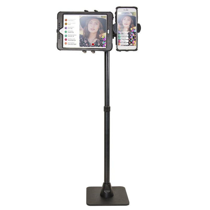The TW Broadcaster Combo Slim-Grip® Ultra 29-inch Stand Holder securely mounts both a tablet and smartphone side by side, showing a woman in a hat live streaming with visible comments and reactions on both screens.