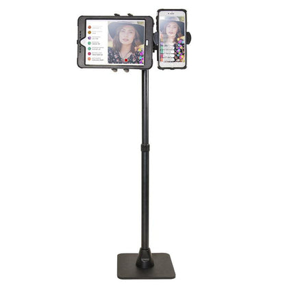 The TW Broadcaster Combo Slim-Grip® Ultra 29-inch Stand Holder securely mounts both a tablet and smartphone side by side, showing a woman in a hat live streaming with visible comments and reactions on both screens.